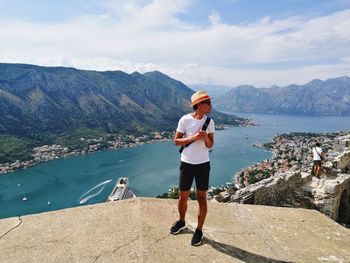 Full length of man standing on mountain against sea