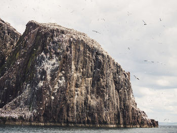 Rock formation on sea against sky