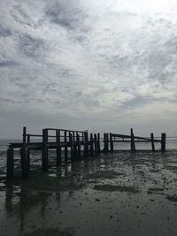 Scenic view of beach against cloudy sky