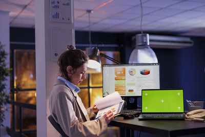 Side view of woman using mobile phone in office