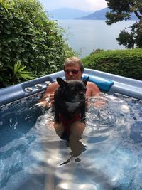 Portrait of happy boy with dog in swimming pool