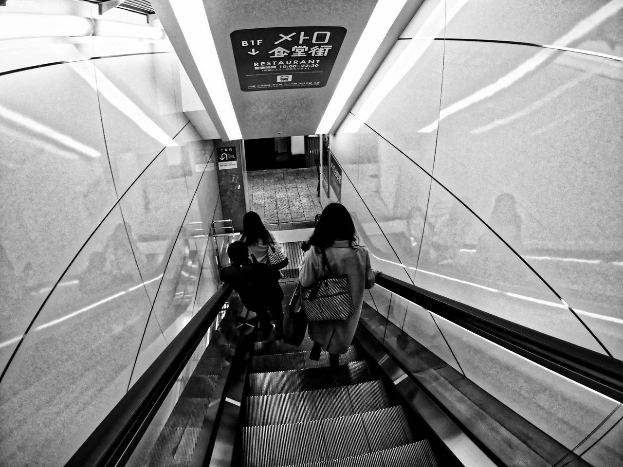 two people, steps and staircases, steps, railing, lifestyles, staircase, real people, indoors, rear view, togetherness, passenger, friendship, women, men, adults only, public transportation, people, adult, moving walkway, day