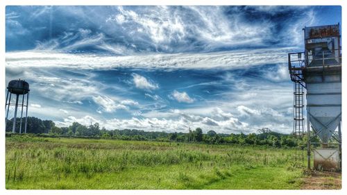 Scenic view of grassy field against cloudy sky