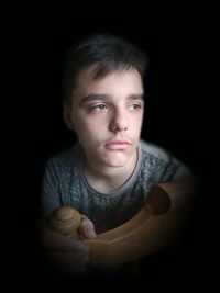 Portrait of boy holding black background