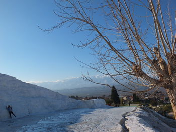 Scenic view of snow covered mountains against blue sky