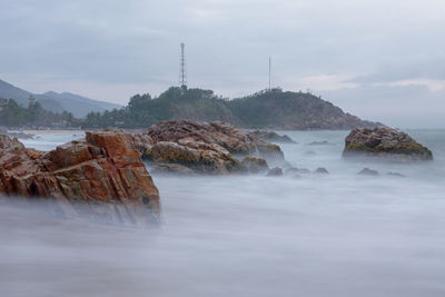 Scenic view of rocks in sea against sky