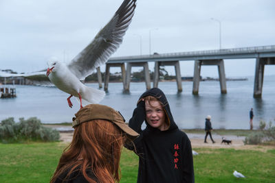 Rear view of young woman standing in sea