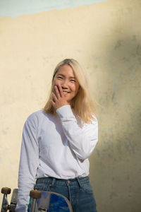 Young woman smiling while standing against blurred background