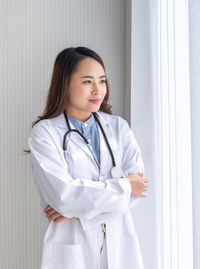 Beautiful young woman standing in front of wall