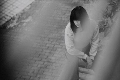 High angle view of woman sitting at balcony