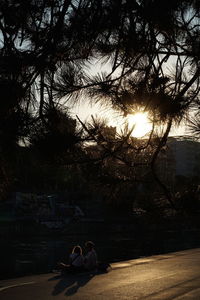 People relaxing in park against sky