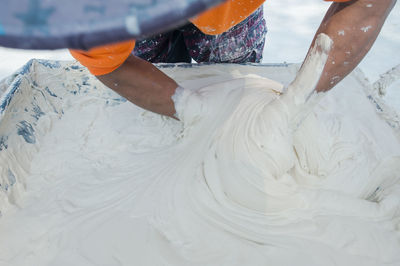 Cropped image of man mixing dough in container