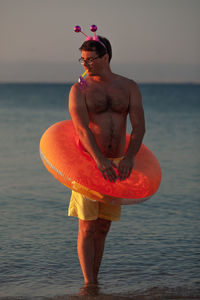 Man wearing sunglasses standing on beach