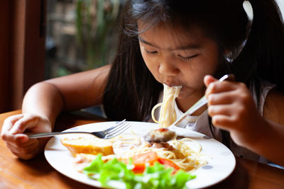 Girl eating noodles at home