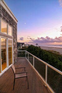 View of swimming pool by building against sky during sunset