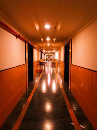 Empty corridor along illuminated building