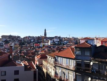 High angle view of houses in town against clear blue sky