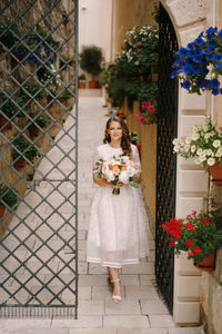 Woman standing by potted plants