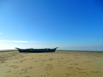 Scenic view of beach against blue sky