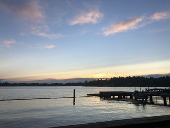 Pier over lake against sky during sunset