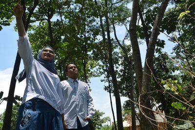 Couple standing against plants