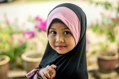 Portrait of cute girl in hijab outdoors