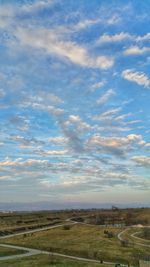 Scenic view of field against cloudy sky