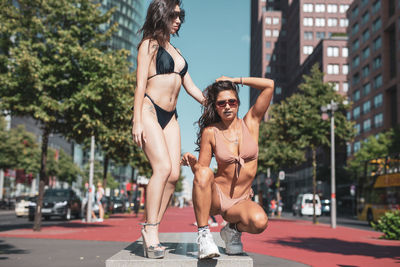 Fashionable young women wearing bikinis in city