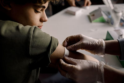 Female healthcare worker applying bandage to boy's arm