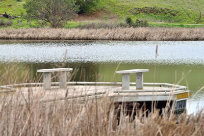 Built structure on field by lake