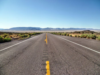 Road passing through landscape against clear sky