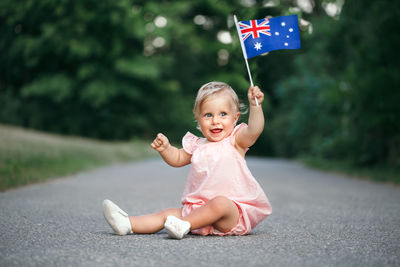 Baby girl waving australian flag. celebration of national australia day in january outdoor.