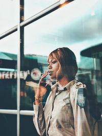 Woman standing in city against sky