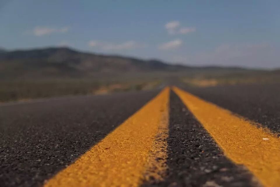 surface level, road marking, asphalt, the way forward, road, diminishing perspective, transportation, selective focus, vanishing point, street, sky, tranquility, empty road, outdoors, no people, empty, tranquil scene, textured, direction, nature