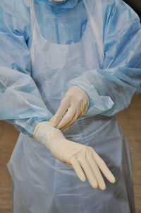 Midsection of surgeon wearing surgical glove in hospital