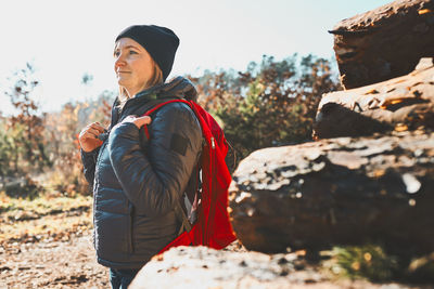 Woman enjoying hike on sunny day. female with backpack walking through forest. spending vacations