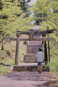 Rear view of woman standing by staircase