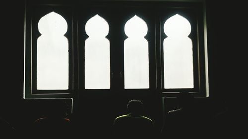 Rear view of silhouette woman in illuminated building