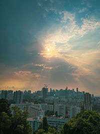 Buildings in city against sky during sunset