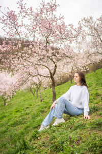 Portrait of young woman sitting on grassy field