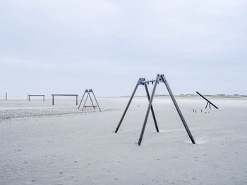 Cranes on playground against sky