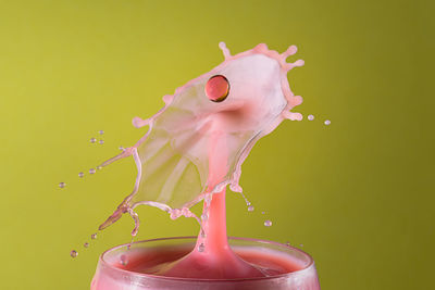 Close-up of drink splashing against green background