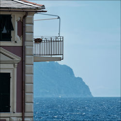 Building by sea against clear sky