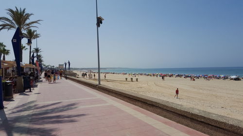 People on beach against clear sky
