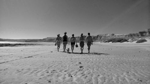 People on beach against clear sky