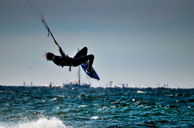 Man jumping in sea against clear sky