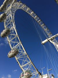 Low angle view of ferris wheel against blue sky