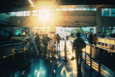 People walking at station during sunny day