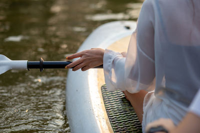 A gentle woman's hand was holding a paddle on a boat. relax with water activities