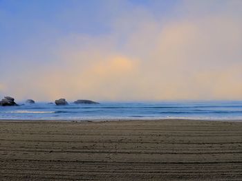 Scenic view of beach against sky during sunset
